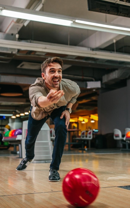 shot-attractive-young-man-throwing-bowling-ball