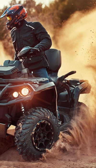 teen-riding-atv-sand-dunes-making-turn-sand