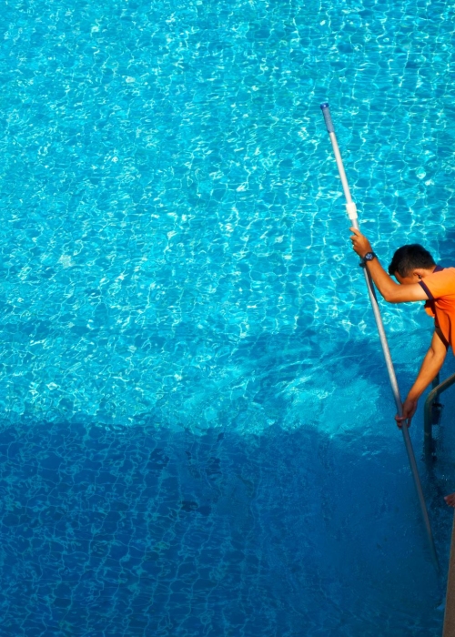 top-view-worker-cleaning-swimming-pool-private-house-summer